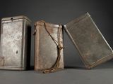 two old metal tins with a rope around them on a gray surface