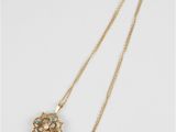 a gold and turquoise necklace with a flower pendant