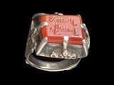 une image représentant une bague en argent avec une pierre rouge au centre