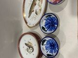cinq assiettes ornées de poissons et de fleurs, accrochées au mur