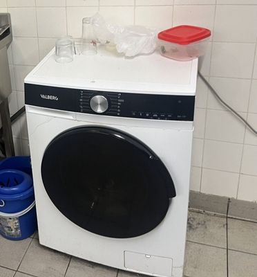 une machine à laver et une poubelle dans une cuisine
