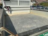 a skateboarder doing a trick on a ramp in the back of a truck