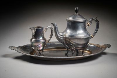 a silver plate with a silver tea pot and a silver cup on it