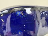 a close up of a blue glass object on a white surface