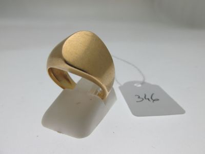 une image d'une bague en or sur une surface blanche avec une étiquette de prix