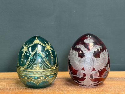 two different colored eggs sitting on a wooden table