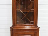 a wooden china cabinet with glass doors and drawers