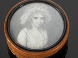 portrait d'une femme coiffée d'un bonnet, dans un coffret en bois