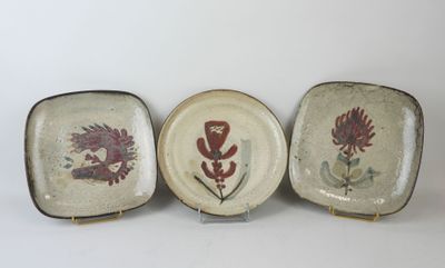 three plates with different designs on them sitting on a white surface