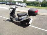 a scooter parked in a parking lot with cars in the background