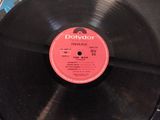 a black record on a table with a red label on it