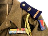 a brown jacket with a blue tie and a badge on it