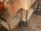 a kitchen with a stainless steel table and a metal shelf
