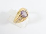 yellow gold ring with amethorate and diamonds on a clear acrylic block