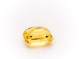 a yellow sapphire stone on a white background
