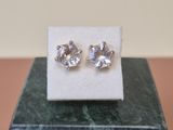 a pair of earrings sitting on top of a marble block
