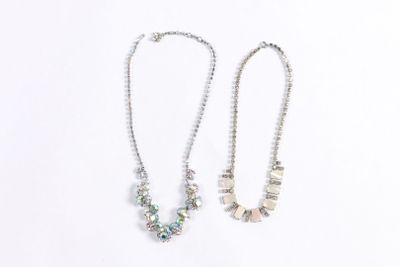 two silver necklaces on a white background with a white background