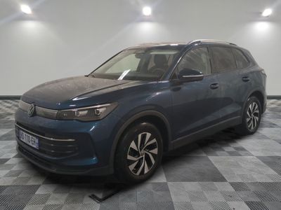 a blue volkswagen suv parked on a checkered floor in a garage