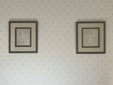 deux tableaux encadrés accrochés au mur au-dessus d'un lit