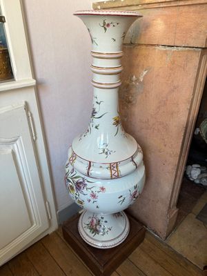 a tall vase sitting on a wooden stand in a room