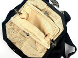 a black purse with a black handle on a white surface