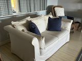 a white couch sitting in a living room next to a window