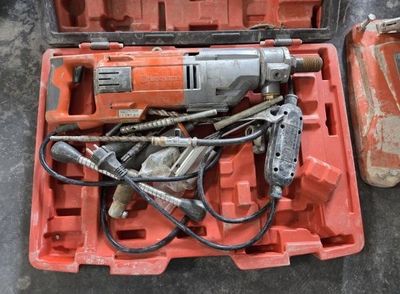 une mallette orange contenant des outils, posée par terre
