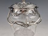 an antique silverplated glass jar with a lid and handles