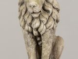 statue of a lion sitting on a stone block on a table