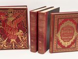 trois livres sont alignés sur une surface blanche