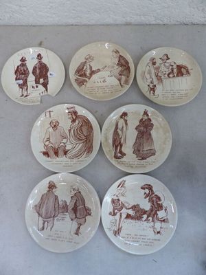 plusieurs assiettes ornées de dessins représentant des personnes et des animaux, posées sur une table
