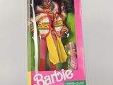 poupée Barbie dans une boîte rose posée sur une surface blanche avec un fond rose