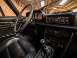 a dashboard and steering wheel of a car with a brick wall in the background