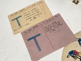 two pieces of paper with letters on them on a table