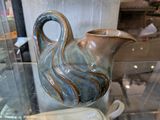un vase bleu et marron posé sur une table en verre
