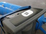 a trash can with a sticker on it sitting in a parking lot