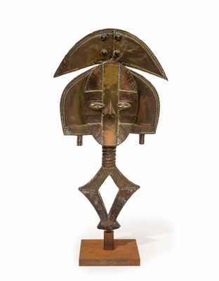 une photo d'une sculpture en bronze représentant un oiseau, posée sur un socle en bois