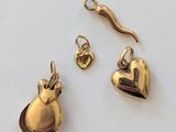 deux bijoux en or posés sur une surface blanche