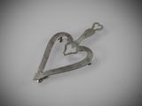 a small metal heart shaped object on a white surface