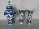 deux vases bleus et blancs et un petit vase posés sur une table