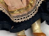 a close up of a doll on a white surface