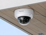 une caméra blanche fixée sur le côté d'un immeuble