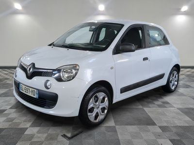 la petite voiture blanche est garée sur un sol en damier