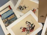 many asian paintings displayed on a table in a box