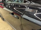 a black car with a red stripe parked in a garage