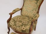 an old chair with a foot stool sitting on top of it