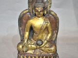 statue of a buddha sitting on a chair with a ball in his hand