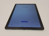 the tablet is sitting on a white surface with a blue screen