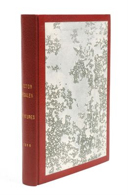 un vieux livre à la couverture rouge posé sur une surface blanche