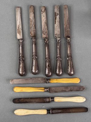 six knives are lined up on a table next to each other